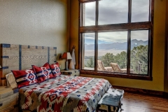 Traditional Mountain Home Design Master Bedroom with Oversized Window and Outdoor Porch